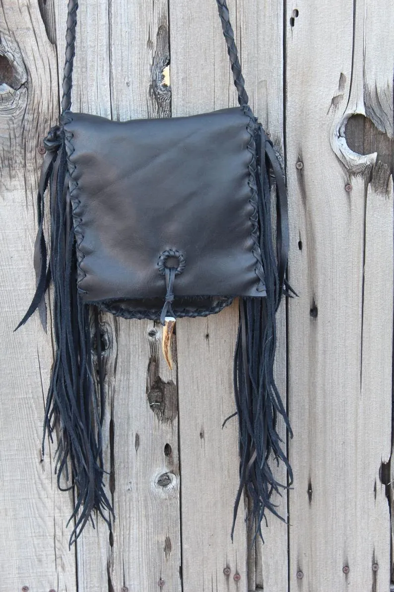 Black leather handbag with fringe and an antler tip closure